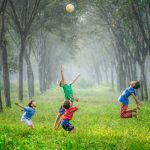 Kids Storage - four boy playing ball on green grass