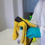 Deep Cleaning - person in white robe holding black and yellow umbrella