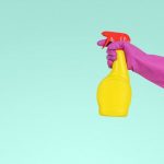 Bathroom Cleaning - person holding yellow plastic spray bottle