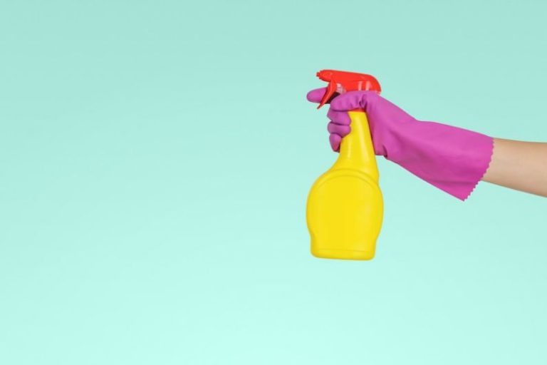 Bathroom Cleaning - person holding yellow plastic spray bottle